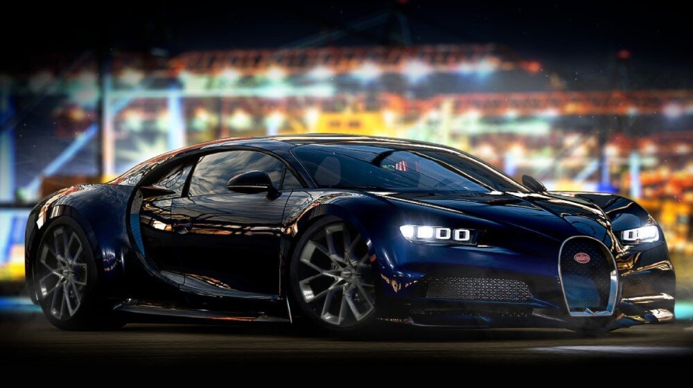 Luksusowy, granatowy samochód sportowy Bugatti Chiron z włączonymi światłami na tle nocnego miasta z rozmytymi światłami, symbolizujący szybkość, moc i premium design. - Ekran o przekątnej 15,6 cala i rozdzielczości Full HD, odświeżanie