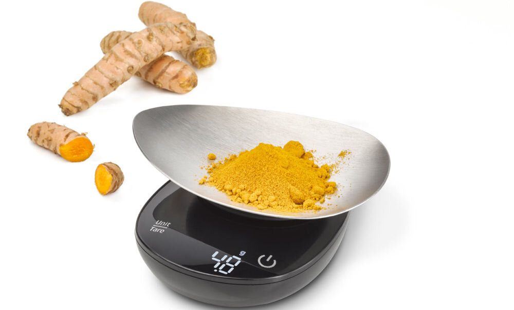 Waga CASO FinoCompact waga czarna obudowa srebrna misa w misce żółta przyprawa obok lezy imbir wyświetlacz białe tło Elegancka, stalowa konstrukcja trwałość łatwe utrzymanie w czystości misa ważąca ze stali nierdzewnej do użycia z innymi pojemnikami Biały, czytelny wyświetlacz LED intuicyjne sterowanie niewielkie wymiary (80 x 33 x 115 mm) praktyczny pasek mocujący łatwe przechowywanie 