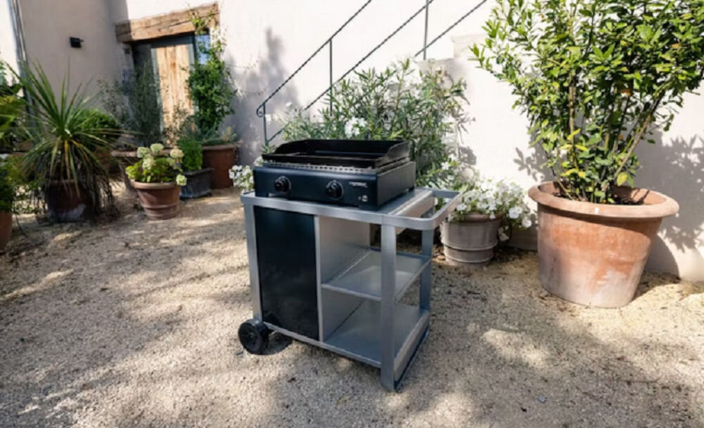 Grill gazowy CAMPINGAZ Plancha Othello 2, smażenie, grillowanie, ogród, komfort, grill stoi w ogródku frontem prawo skos