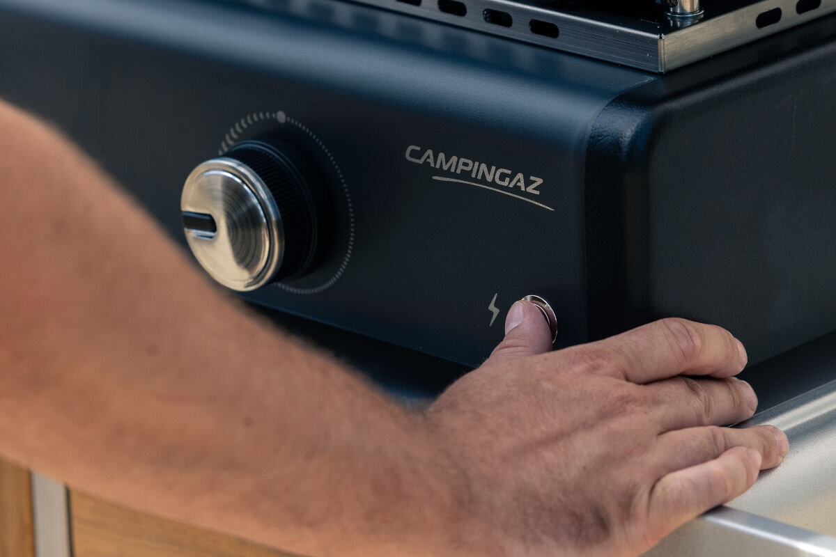 Grill gazowy CAMPINGAZ Plancha Sigma 2 cook, przycisk, Elektroniczny, zapalnik, płomień, dłoń przyciska Elektroniczny zapalnik by rozpalić grilla