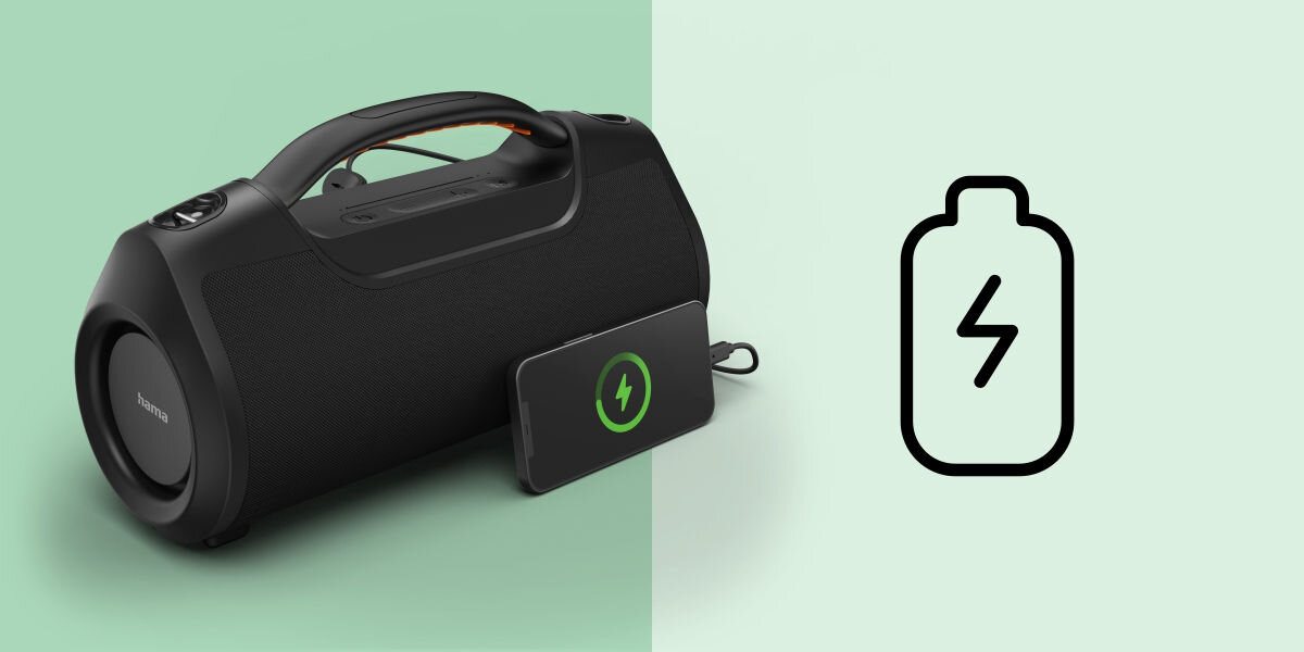 Czarny głośnik mobilny z uchwytem i panelem sterowania na górze, obok niego leży urządzenie z symbolem ładowania. Po prawej stronie widoczna jest ikona baterii z błyskawicą.