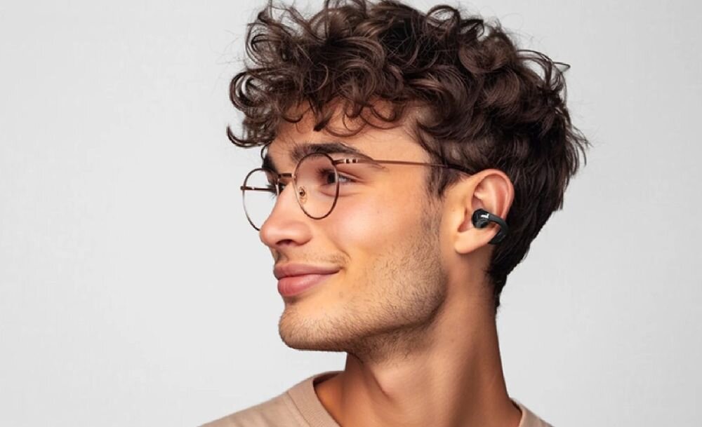 Słuchawki powietrzne QCY Crossky Clip T33 konstrukcja wrap around i komfort z okularami, osoba z załozonymi słuchawkami powietrznymi