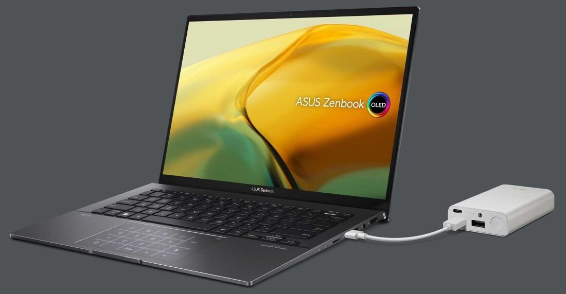Laptop ASUS ZenBook UM3402 podłączony do powerbanku przez port USB-C, ekran z napisem ASUS Zenbook OLED, klawiatura z podświetlanym panelem numerycznym.