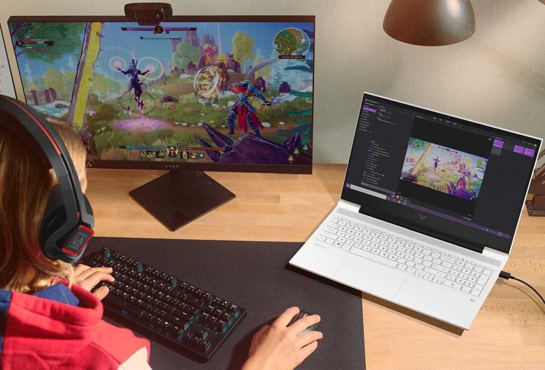 Kobieta pracuje na laptopie HP Victus 15, używając myszki i klawiatury. 