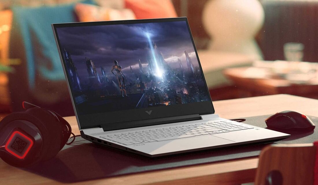 Laptop HP Victus 15 - Osoba grająca w grę wideo na laptopie, skupiona na ekranie, otoczona przyjemną atmosferą. AMD Ryzen, NVIDIA GeForce RTX 