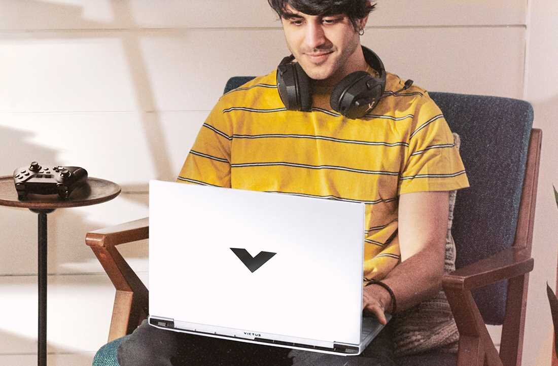 Laptop HP Victus 15 - Mężczyzna w słuchawkach siedzi na krześle, używając laptopa do pracy. Pamięć DDR5, Dysk SSD PCIe NVMe 4.0