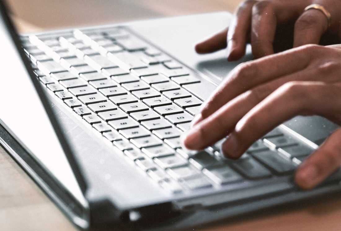 Laptop HP Victus 15 - Osoba korzystająca z laptopa, pisząca na klawiaturze, z wyraźnym skupieniem i otoczeniem sprzyjającym pracy. pełnowymiarowa klawiatura z podświetleniem 