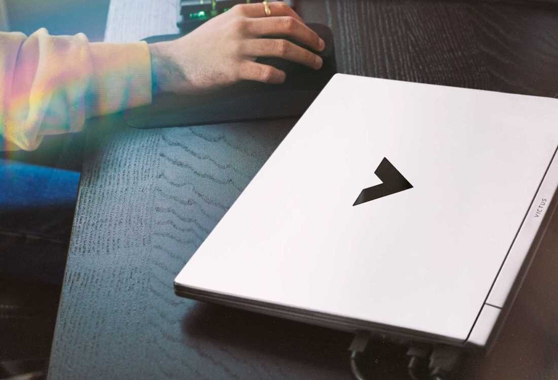 Laptop HP Victus 15 - Osoba korzystająca z laptopa, na którym widoczne jest logo HP Victus. Wi-Fi 6 Bluetooth 5.3 
