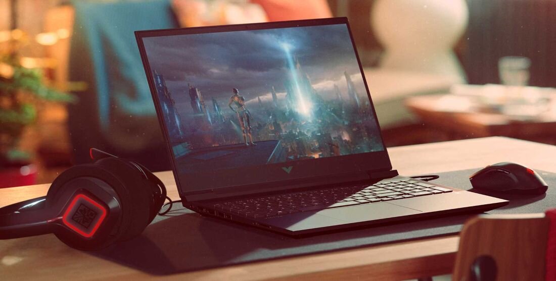 Kobieta pracuje na laptopie HP Victus 15, używając myszki i klawiatury.