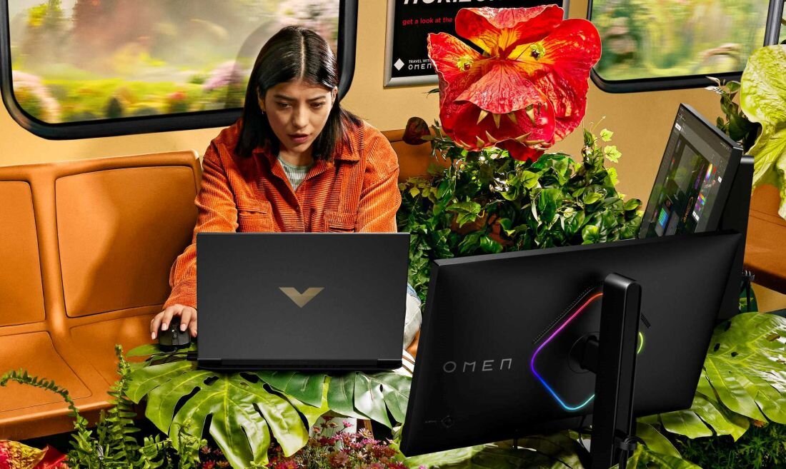 Laptop HP Victus 16 - Kobieta siedząca w pociągu, korzystająca z laptopa, skupiona na pracy lub nauce w podróży.