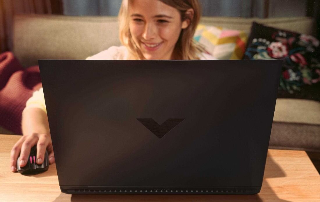 Laptop HP Victus 16 - Uśmiechnięta kobieta pracuje na laptopie, ciesząc się chwilą i efektywnością swojej pracy.  