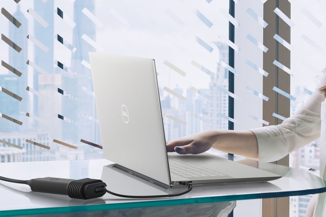 Kobieta korzysta z laptopa DELL XPS 9640, siedząc przy stole. - funkcja rozpoznawania twarzy i czytnik linii papilarnych