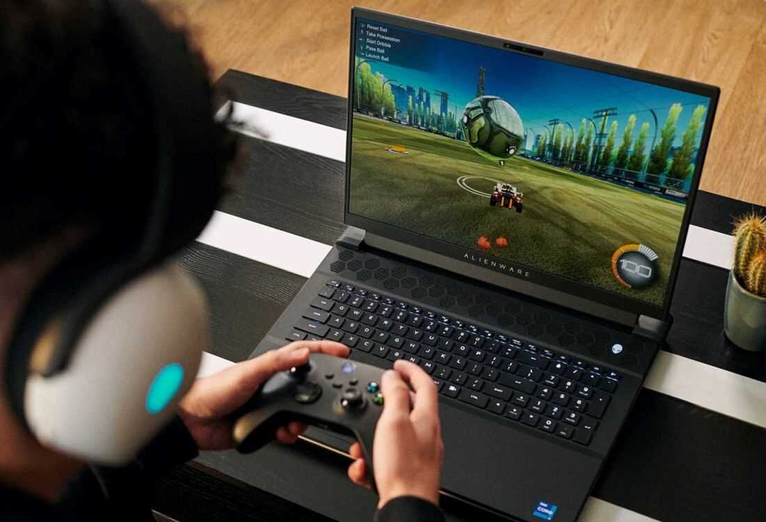 Laptop DELL Alienware M18 R2 18R2 - Osoba grająca w grę wideo na laptopie DELL Alienware M18, skupiona na ekranie i kontrolerze.  