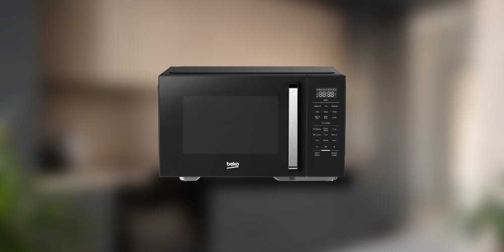 KUCHNIA MIKROFALOWA BEKO MCF26310BAF Kuchenka mikrofalowa Beko na rozmytym tle kuchni. Prosty, stalowy design