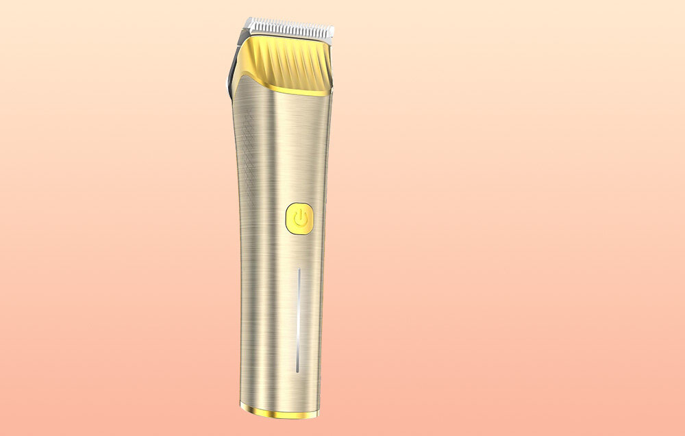 Trymer do strzyżenia zwierząt w kolorze złotym z widocznym przyciskiem zasilania na obudowie. Tło jest w odcieniach jasnego różu.