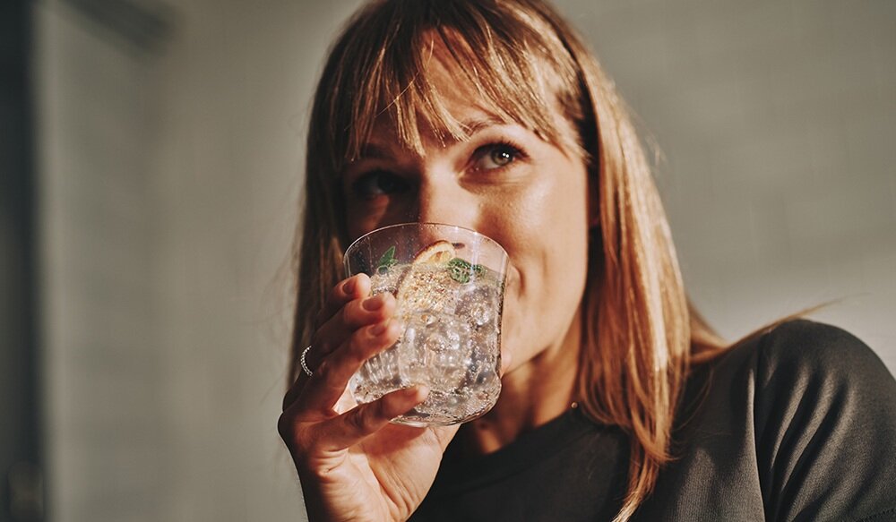Saturator SodaStream Terra Czarny kobieta pijąca gazowaną wodę, samodzielne gazowanie wody, oszczędność czasu, ekologia