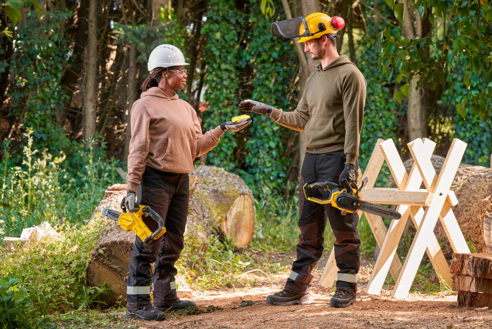 Piła akumulatorowa STANLEY 18V Fatmax V20 SFMCCS730M1-QW las dwoje ludzi wymienia się akumulatorem w dłoniach mają piły w tle drzewa powalone pnie drzew liście akumulator z serii STANLEY Fatmax V20 o pojemności 4,0 Ah (w zestawie) brak efektu pamięci niskie samorozładowanie pełna swoboda ruchu pracy w dowolnym miejscu ogrodu wspólny system zasilania STANLEY Fatmax V20 jeden akumulator w wielu narzędziach