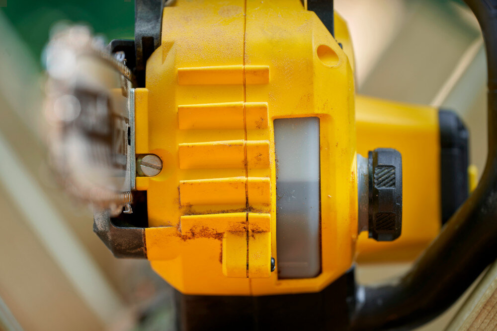 Piła akumulatorowa STANLEY 18V Fatmax V20 SFMCCS730M1-QW zbliżenie na zbiornio oleju widok od tyłu automatyczny system olejenia ciągłe smarowanie łańcucha podczas pracy zmniejsza tarcie i spowalnia zużycie prowadnicy pojemność zbiornika oleju 150 ml ogranicza ryzyko zapieczenia elementów roboczych utrzymanie narzędzia w dobrej kondycji