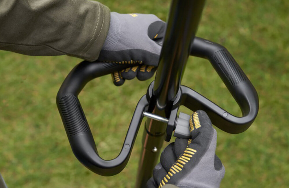 Podkaszarka akumulatorowa STANLEY SFMSTB930M-QW ogród trawnik zbliżenie na uchwyt pomocniczy osoba reguluje uchwyt regulowany uchwyt pomocniczy wyważona konstrukcja waga około 3,28 kg zmniejsza obciążenie ramion większa kontrola ruchów i mniejsze zmęczenie