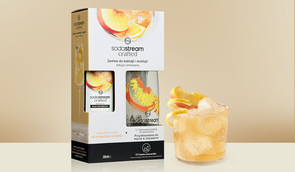 Zestaw upominkowy SODASTREAM Crafted Brzoskwinia & Imbir jasne tło rysunki opakowanie syrop butelka obok stoi napój w szklance bąbelkowa przyjemność owocowa słodycz brzoskwini subtelny pikantny akcent imbiru