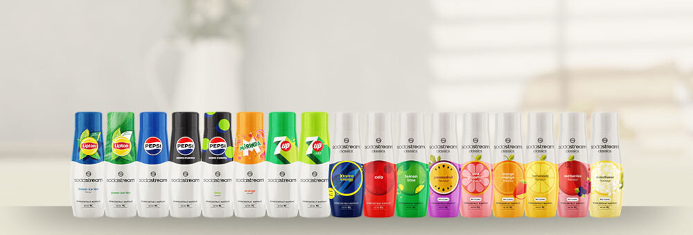 Zestaw upominkowy SODASTREAM Crafted Brzoskwinia & Imbir jasne tło ustawione butelki różne rodzaje napoje kolorowe opakowania bąbelkowe inspiracje świat różnorodnych napojów pełna swoboda wyboru klasyczne smaki Pepsi Mirinda 7Up zdrowe opcje owocowe warianty bez dodatku cukru Czarny Bez, Marakuja i Lemoniada miejsce kreatywności odkrywanie różnych smaków