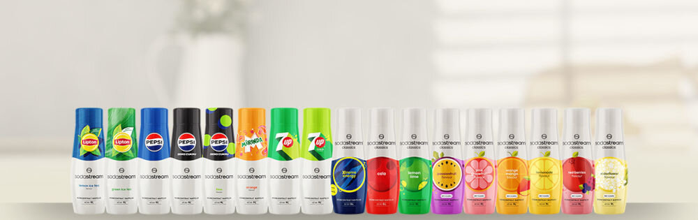 Zestaw upominkowy SODASTREAM Crafted Kit Coral jasne tło ustawione butelki różne rodzaje napoje kolorowe opakowania szeroka gama klasyczne syropy pełna swoboda wyboru klasyki kwiat czarnego bzu marakuja orzeźwiająca lemoniada tradycyjne smaki pepsi mirinda 7 Up zdrowe opcje owocowe warianty bez dodatku cukru różnorodność smaku