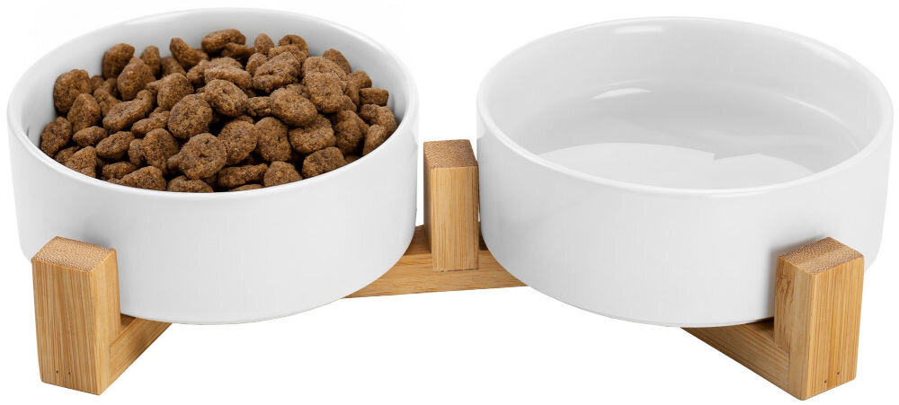 Miska dla psa i kota ZWIERZOPASJA Jax Na zdjęciu znajduje się biała, ceramiczna miska oraz drewniany stojak o prostym, geometrycznym kształcie. Miska jest umieszczona obok stojaka, który ma cztery pionowe podpórki