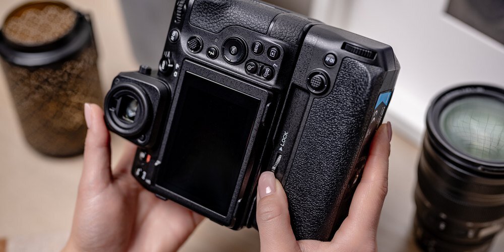 Lustrzanka Nikon Z8 z przymocowanym gripem MB-N12 w kobiecych dłoniach. Ujęcie od strony wyświetlacza
