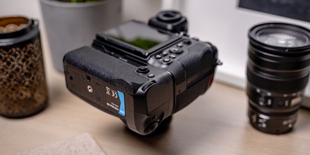 Lustrzanka Nikon Z8 z przymocowanym gripem MB-N12 na drewnianym blacie. Zdjęcie ukazuje gwint 1/4