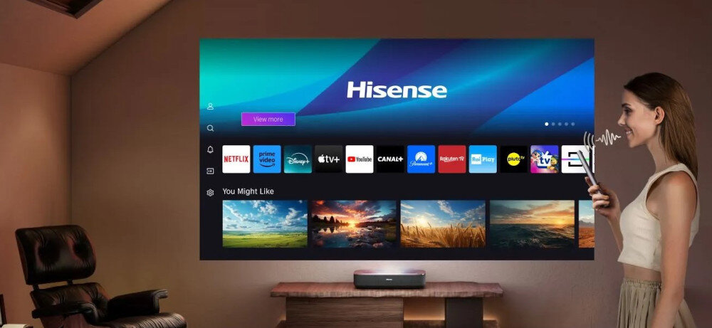 Projektor HISENSE PL2 - Szybki dostęp do serwisów VOD, KOBIETA MÓWI DO pilota. projektor stoi na stoliku