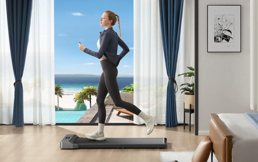 Bieżnia elektryczna KINGSMITH Z1 Fold Walking Device 550W 6km-h kobieta biegnie na bieżni czytelny panel łatwe monitorowanie postępów pilot zdalnego sterowania zasilany bateriami AAA