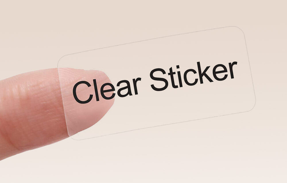 Przezroczysta naklejka z napisem \'Clear Sticker\' trzymana na palcu.