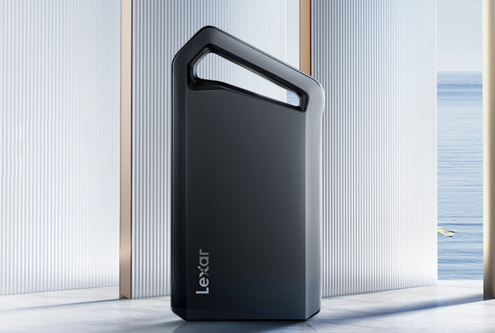 Dysk LEXAR SL600 Przenośny dysk zewnętrzny o ciemnoszarej obudowie z napisem Lexar, ustawiony pionowo na jasnej powierzchni. Urządzenie posiada charakterystyczny trójkątny otwór w górnej części pełniący rolę uchwytu
