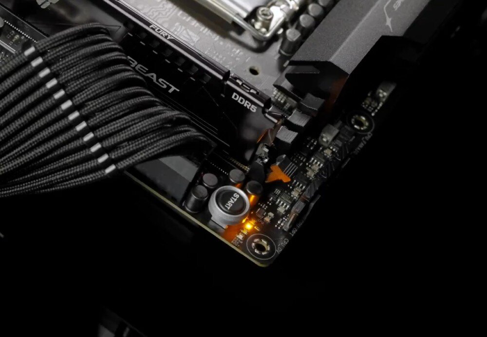 Płyta główna ASUS ROG Strix B860-I Gaming WiFi Zbliżenie na dolny prawy róg płyty głównej z widocznymi złotymi kondensatorami audio i przyciskiem 'Q-Start'