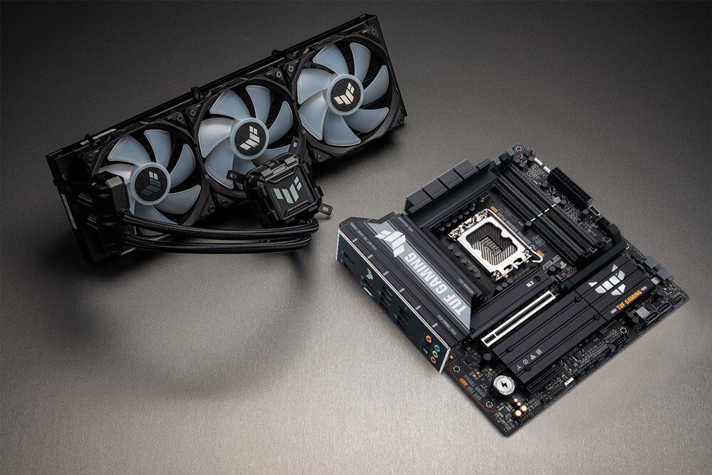 Płyta główna ASUS TUF Gaming B860M Plus Płyta główna leżąca na płaskiej powierzchni obok zestawu chłodzenia wodnego z trzema wentylatorami