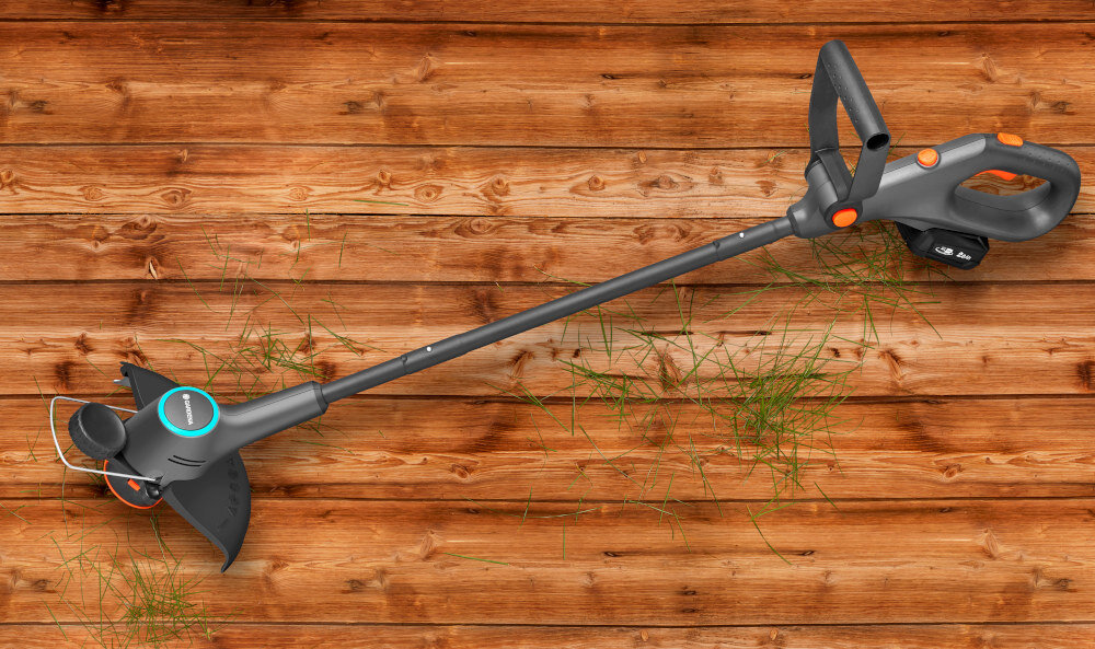 Podkaszarka akumulatorowa GARDENA EasyTrim 14704-55 podkaszarka na drewnianej podłodze wydajność komfort pomoc przy pielęgnacji ogrodu zasilanie akumulatorowe