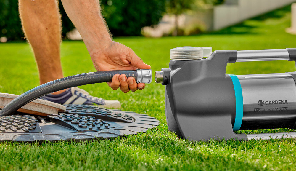 Wąż ssący GARDENA 9092-20 4 m ogród wąż umieszczony w studzience kanalizacyjnej osoba podłącza wąż do pompy nakrętka przyłączeniowa gwint 33,3 mm (G1) gwint 25 mm wszechstronne wykorzystanie w różnych systemach nawadniających i instalacjach wodnych