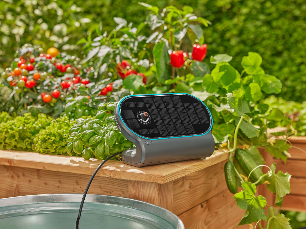 Zestaw do nawadniania GARDENA AquaBloom 13330-20, pogoda, system, zaplanowanie, wyjazd, w tle ogród warzywny, na pierwszym planie panel słoneczny nawadniacza