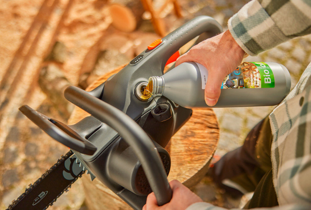 Piła akumulatorowa GARDENA PowerSaw 14790-55 osoba nalewa olej do piły zintegrowany system smarowania LubriTec optymalne smarowanie łańcucha i prowadnicy hartowane nity wytrzymała chromowana warstwa zewnętrzna łańcucha odporność na uszkodzenia redukują konieczność częstej regulacji