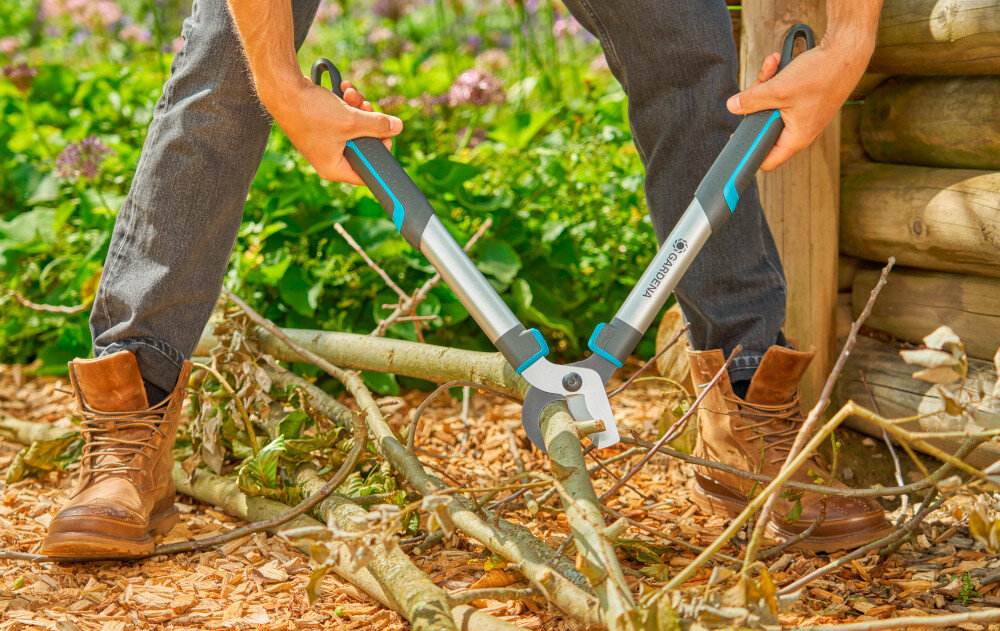 Nożyce do gałęzi GARDENA Easycut S 12030-20 ogród drzewa osoba tnie ścięte gałęzie na kawałki drewniany płot cięcie boczne dwa ostrza przesuwają się obok siebie gładka powierzchnia cięcia sprzyja naturalnemu gojeniu się roślin