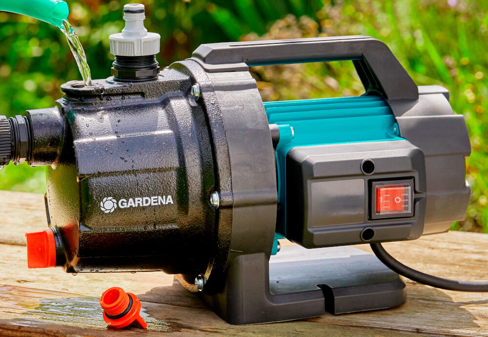 Pompa ogrodowa GARDENA 3700 Basic 9014-47 elektryczna pompa ustawiona na drewnianej podłodze w tle rośliny ceramiczne uszczelki wał ze stali nierdzewnej żeliwna obudowa podwójne uszczelnienie umieszczone między silnikiem a napędem ochrona wnętrza przed wilgocią i zanieczyszczeniami klasa zabezpieczenia elektrycznego IPX4 ochrona przed wodą rozbryzgową ze wszystkich stron