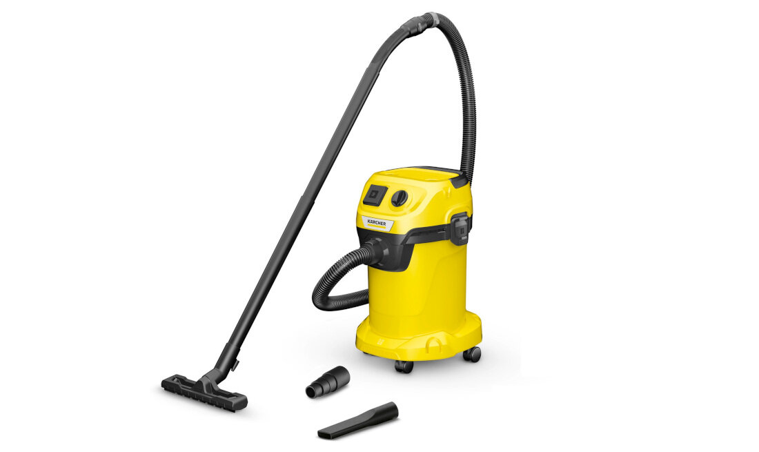 Żółty odkurzacz z czarnymi elementami, wyposażony w długi wąż i różne końcówki. Na urządzeniu widoczne jest logo KARCHER.