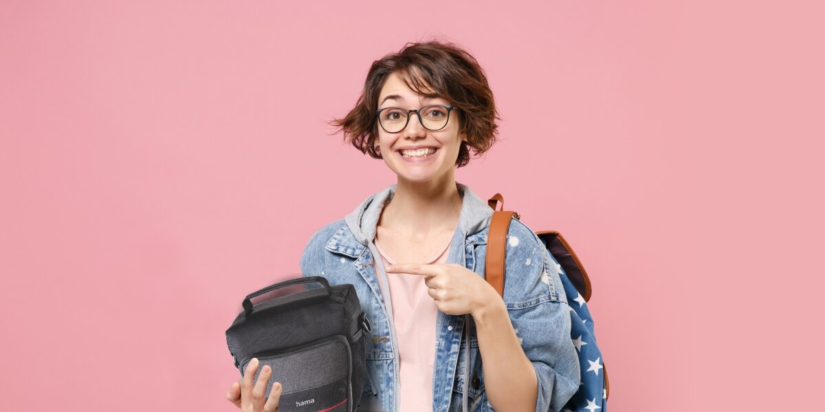 Torba HAMA Valetta 110 Colt Czarny Bezpieczne przechowywanie - uśmiechnięta osoba wskazująca na torbę trzymaną w ręce