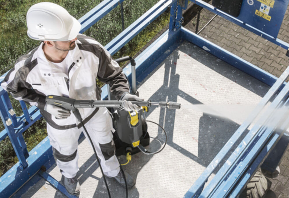 Myjka ciśnieniowa KARCHER HD 6/13 CX Plus 1.520-952.0 zdjęcie od góry mężczyzna w kasku i stroju roboczym trzyma pistolet i myje powierzchnię obok stoi myjka wytrzymała mosiężna głowica pompy długa żywotność urządzenia wysoka odporność na zużycie system automatycznego obniżania ciśnienia zabezpiecza elementy konstrukcyjne filtr wody ochrona pompy przed zanieczyszczeniami długotrwała praca woda o temperaturze sięgającej 60 stopni łatwiejsze usuwanie uporczywych zabrudzeń 