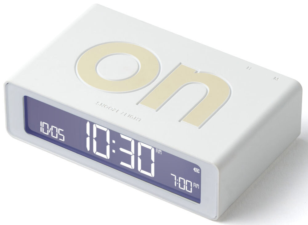 Budzik LEXON Flip Mini Biały, Budzik LEXON Flip Mini budzik na szafce włączanie wyłączanie alarm ekran podświetlony przyciski konfiguracja, Biały budzik na drewnianym stole obok kwiatka.