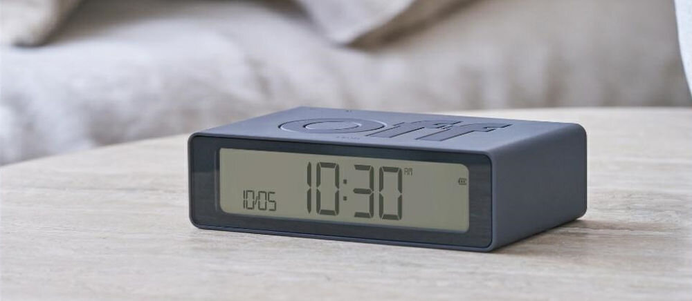 Budzik LEXON Flip Mini Ciemnoszary, podróż, USB-C, bateria, ekran, Klasyczny Lexon Flip Mini z napisem „off”, matowa grafitowa obudowa, jasny blat, wyraźny ekran.