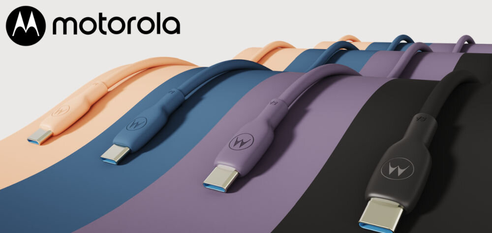 Na obrazie widoczne są cztery kable USB-C w różnych kolorach: pomarańczowym, niebieskim, fioletowym i czarnym, z logo Motorola. Kable leżą na kolorowych paskach odpowiadających ich barwom.