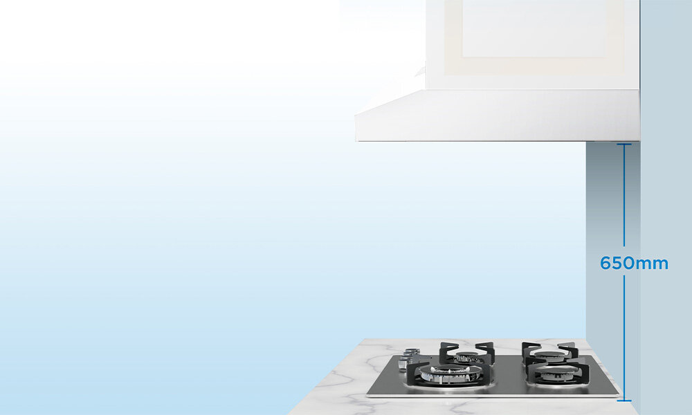 OKAP MIDEA MH60F17EM21WB Zdjęcie przedstawia okap zamontowany nad kuchenką gazową z zaznaczonym pionowym odstępem 650 mm. Obraz pokazuje prawidłową odległość montażową między okapem a płytą kolor biały wygląd