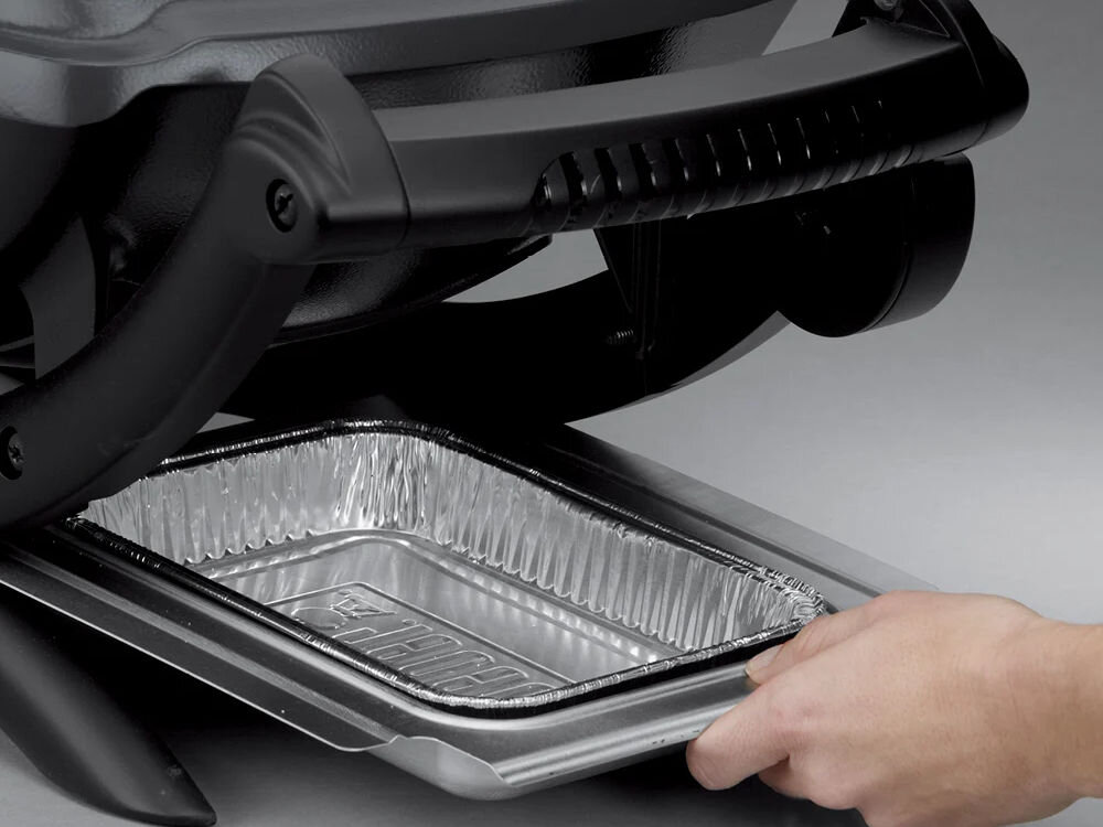 Grill elektryczny WEBER Q 1400 52020879 ze stojakiem, powierzchnia grillowania, pojemność, szybkie dania, stabilność, Wysuwana aluminiowa tacka ociekowa pod grillem Weber Q 1400, ręka trzymająca wyjmowaną tackę.