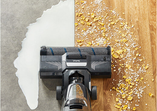 Odkurzacz TEFAL X-Clean 4 czyści płytki z rozlanego mleka i drewnianą podłogę z okruszków.